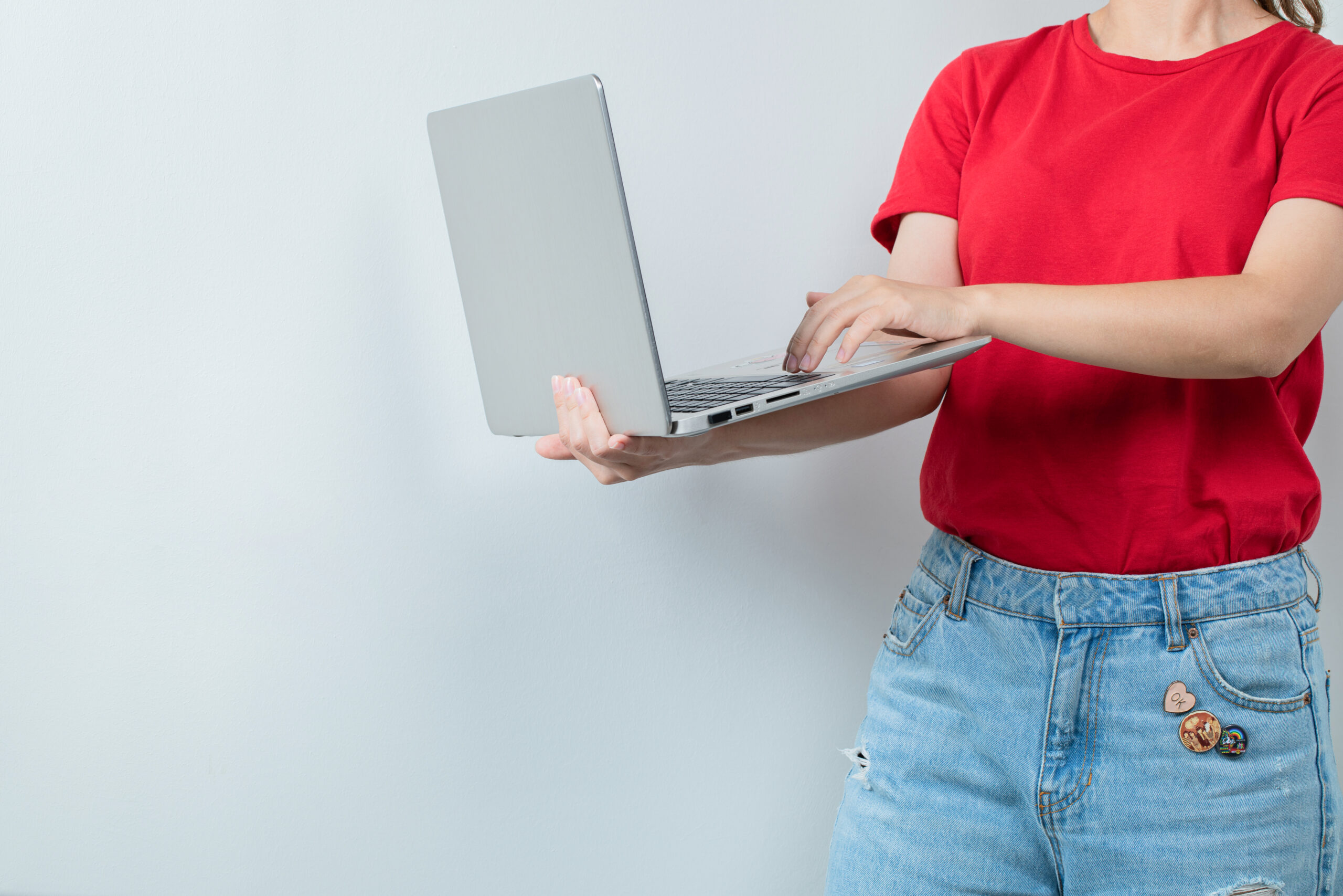 Female student holding a grey laptop