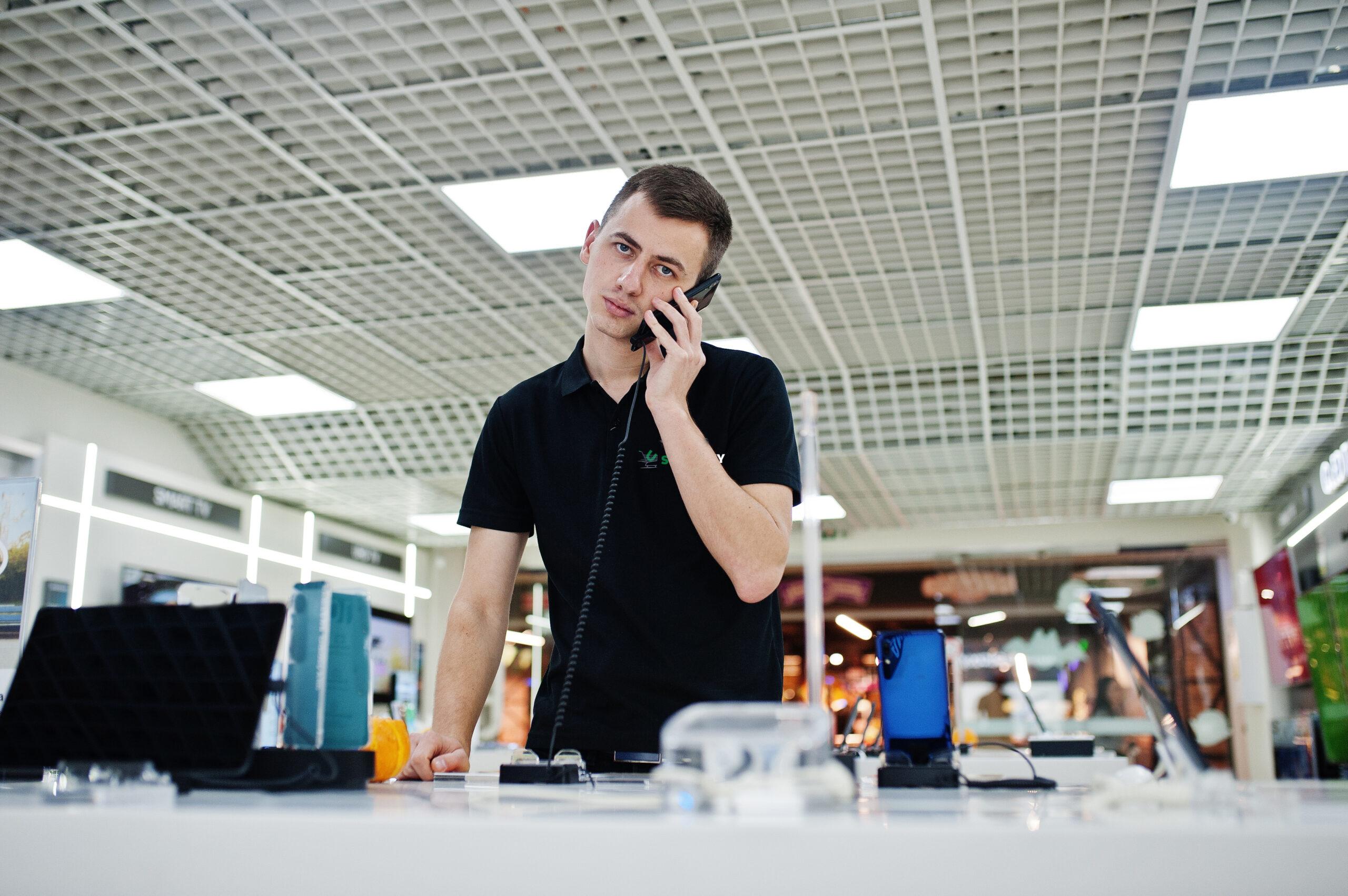 Seller man mobile phone professional consultant in tech store or